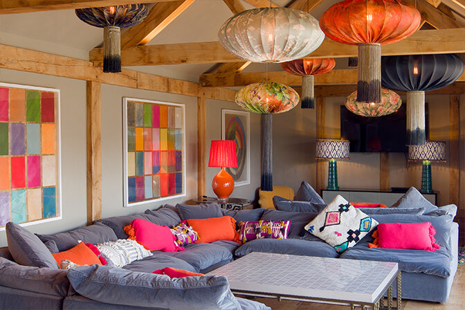 Suspended throughout the colourful snug area are seven more Ume lanterns, with and without tassels, that add a textural lift to the bright colour scheme for this central social space in the property.