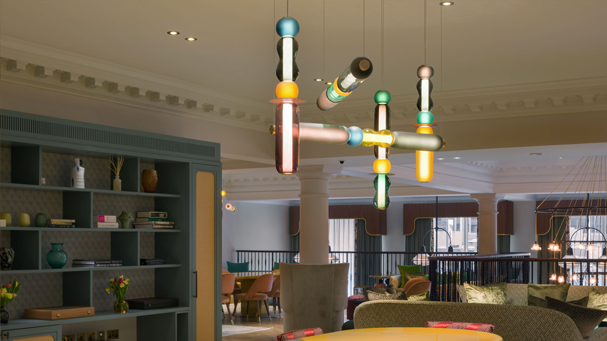 Hand-blown glass horizontal chandelier hanging above a large dining table in The Pavilion Club Knightsbridge.