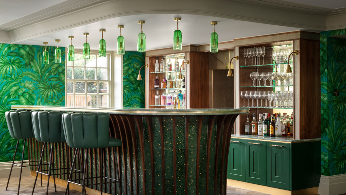 9 Emerald green hand-blown glass pendant lights above an at home bar designed by Chiselwood.