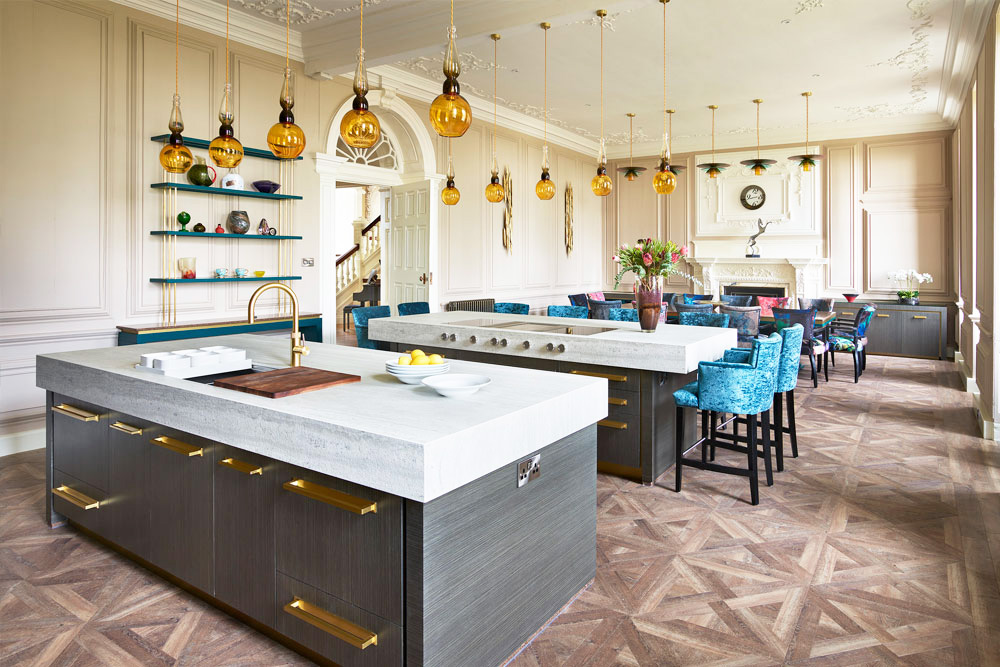 Hand-blown yellow ochre and olive green glass statement pendant lights over luxury kitchen island.