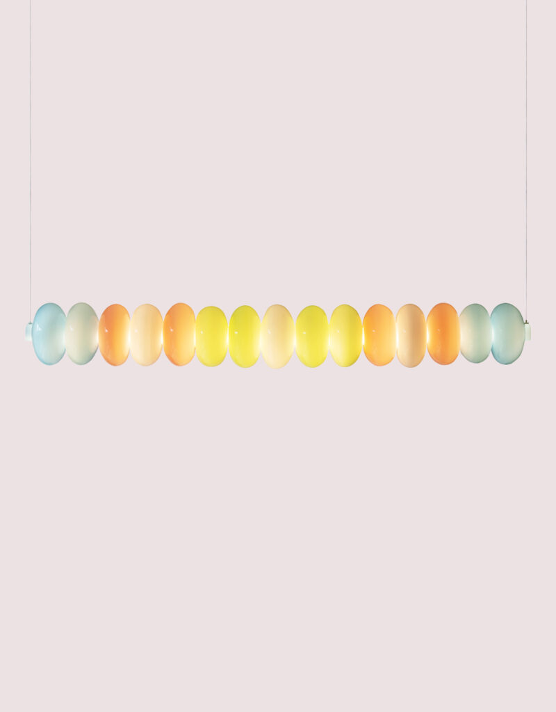 Long glass horizontal beam pendant light in pastel green, blue, and pink coloured glass.