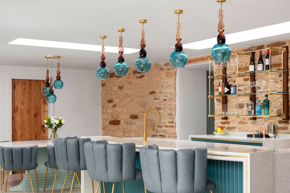Blue and mocha coloured glass hand-made ceiling lights over a contemporary kitchen island.